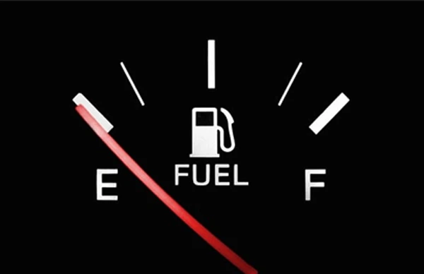 Fuel gauge indicating nearly empty with red needle on E.